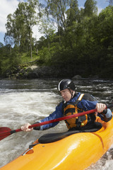 View of a young man kayaking in river