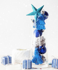 Silver and blue Christmas toys in glass under snow