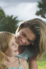 Closeup of a happy mother and daughter talking outdoors