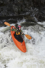Elevated view of a woman kayaking in rough river