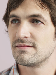 Closeup of thoughtful young man looking away isolated on colored background