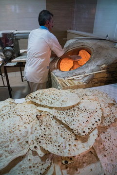 Traditional baker at work at his oven, Ramsar, Iran