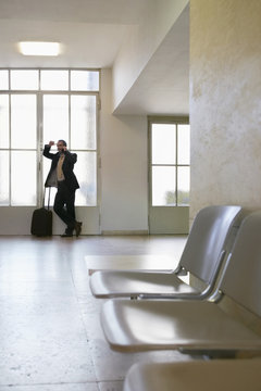 Full Length Of A Businessman Using Mobile Phone In The Airport