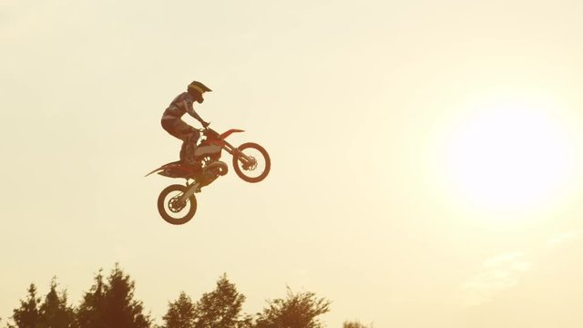 SLOW MOTION: Pro freestyle motocross biker jumping superman trick over the sun