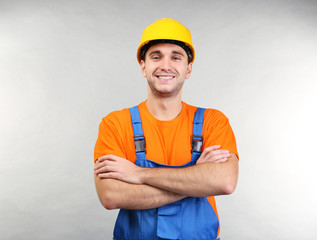 Confident warehouse worker with crossed arms on light background