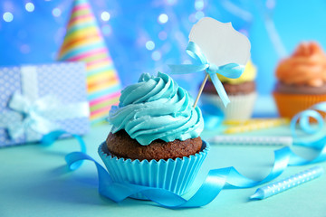 Birthday cupcake with space for text on blurred blue background