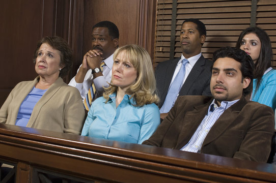 Diverse Group Of Jurors Sitting In Jury Box Of A Courtroom During Trial