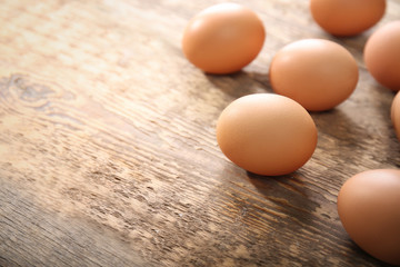 Raw eggs on wooden background