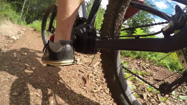 CLOSE UP: Biker man pedaling electric bike on offroad dirt track in forest