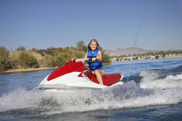 Obraz premium Portrait of happy young riding water scooter on lake