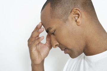 Closeup of an African American man suffering from headache on white background