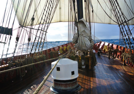 On deck with capstan and sails of a traditional tallship or sailboat