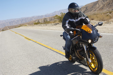 Fototapeta na wymiar Biker riding motorcycle on a country road