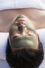 Man wearing mud facial mask at health spa