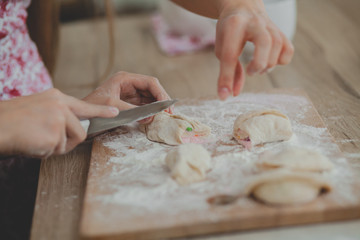 Mother with her daughter are preparing the buns