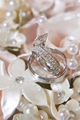 Wedding Rings on top of a Plaster Flower Bridal Bouquet