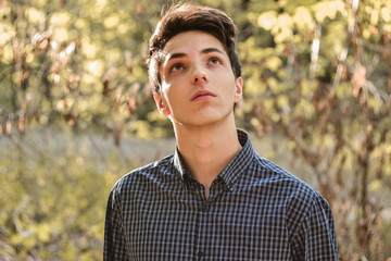 Pensive teenage boy looking up hoping