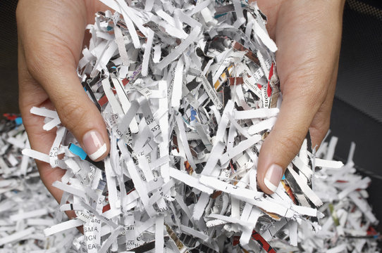 Closeup of female hands holding heap of shredded papers