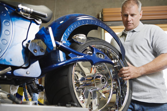 Male Mechanic Fixing Motorcycle In A Garage