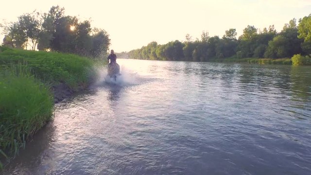 CLOSE UP: Senior man on strong horse trotting in shallow wide river
