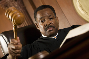 Serious middle aged judge knocking a gavel