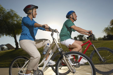 Side view of two Caucasian friends riding bicycles