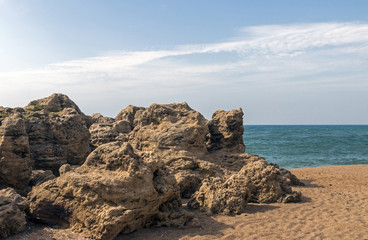 Fototapeta na wymiar Large Rock Formation on Shoreline of Beach