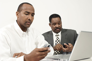 Business executives using cell phones during a meeting
