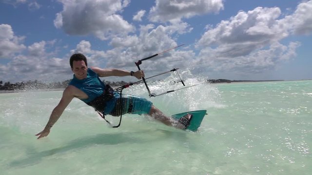 SLOW MOTION CLOSE UP: Happy smiling surfer kiteboarding in exotic island lagoon