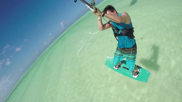 CLOSE UP: Happy young kiter sportsman kiteboarding on perfect turquoise sea