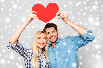 Young smiling family holding paper heart on xmas background
