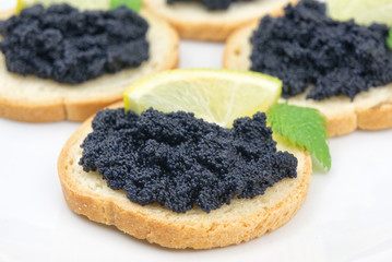 Tartines with caviar and lemon closeup