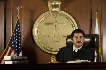 Thoughtful male judge sitting in the courtroom