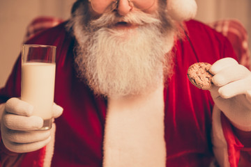 Close up of happy Santa Claus with glass of milk and cookie