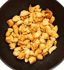Prepared chicken fillet cutted into pieces and spiced in pan isolated over white background