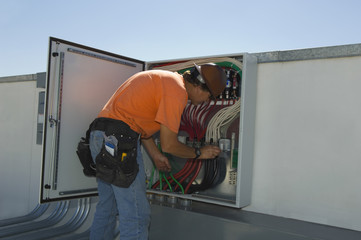 Engineer working on electrical box at solar power plant