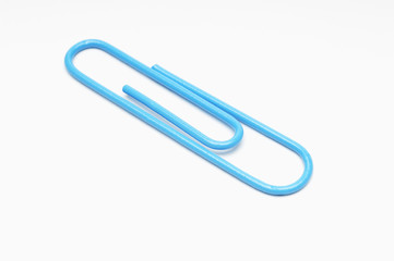 Obraz premium Closeup of blue paperclip over white background