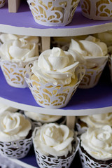 White wedding cupcakes in laser cut holders and Frosting Shaped like Roses