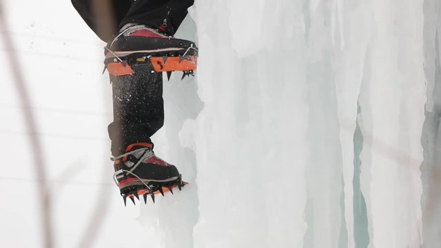Boots with crampons in Ice climbing. Slow motion.