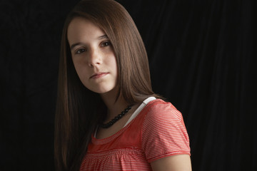 Closeup portrait of confident teenage girl isolated on black background