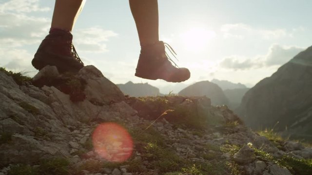 CLOSE UP: Detail of leather boots and hiker walking on dangerous mountain ledge
