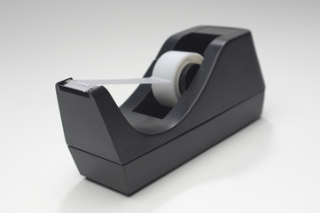 Closeup of a adhesive tape in holder over white background