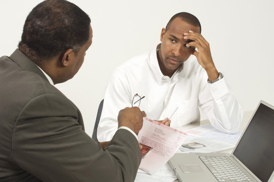 Financial advisor in discussion with tensed businessman in office