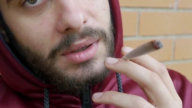 guy with problems of addiction hides himself to smoke weed