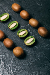 Kiwi fruits are on top of the black kitchen table