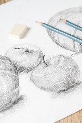 Fototapeta na wymiar Two pencils lie on the drawing of apples