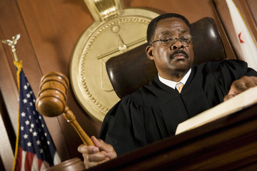 An African American male judge forming sentence in the courtroom