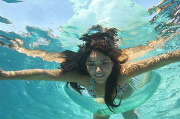 Portrait of a beautiful woman swimming underwater with arms outstretched
