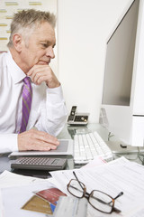 Senior businessman working on computer at office desk