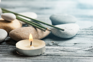 Fototapeta na wymiar Aroma sticks, pebbles and lit candle